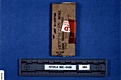 AFDIL Photo depicting closed cardboard slide mailer marked: 'from Q87 PC L2082 PMS MPM' '990111018ZJ RBF JAD' '99C-0438 58A', and scale marked: 'AFDIL #:99-0438-58A'